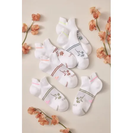 A Bombas image ad: six pairs of white ankle socks laid out with dried orange flowers on a cream background