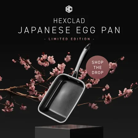 A HexClad image ad: a rectangular Japanese egg pan on a black plinth with cherry blossom behind it