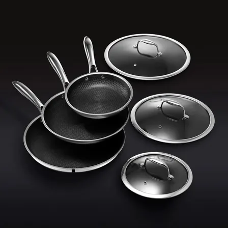A HexClad image ad: a full set of hybrid pans, pots, lids, bowls and knives arranged on a black background