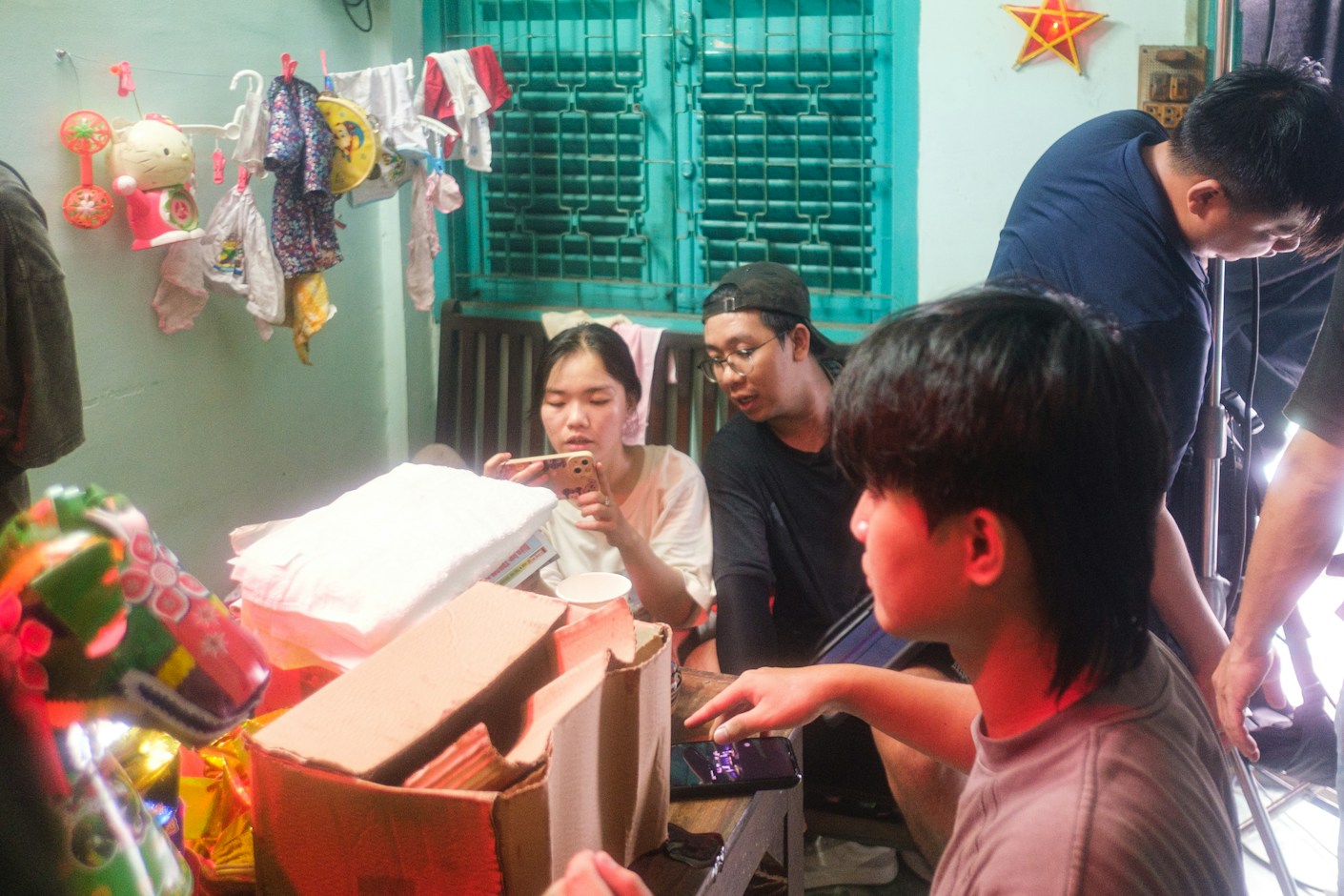 A family gathered around an open box on a table at home, going through what is inside